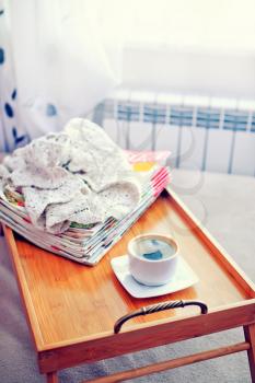 coffee and stack of magazins on wooden tray