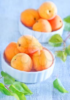 fresh apricots in bowl and on a table