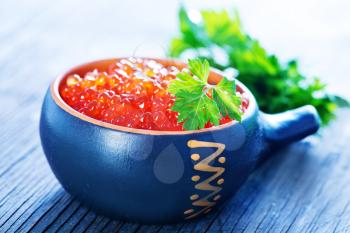 red salmon caviar with fresh parsley on a table