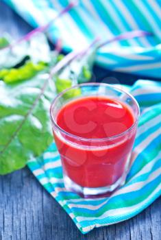 beet juice in glass and on a table