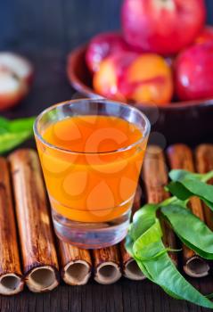 nectarine juice in glass and on a table
