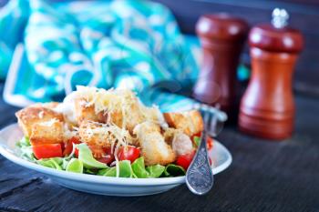 caesar salad on plate and on a table