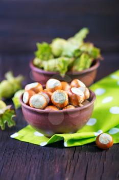 Filtered image of Hazelnuts in a wooden bowl on rustic background