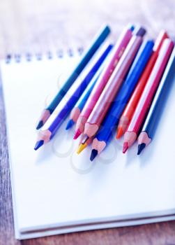 color pencils and note on the wooden table