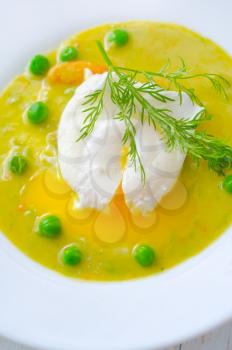Fresh soup from green peas and egg-poached