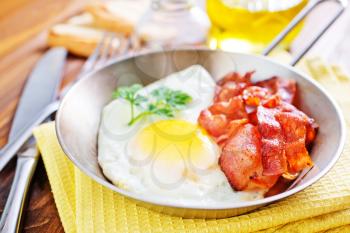 breakfast on a table, fried eggs with bacon in bowl