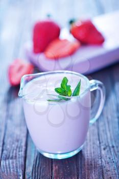 strawberry yogurt in glass jug and on a table