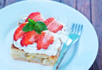 pie with cream and fresh strawberry on plate