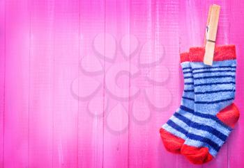 baby socks on the pink wooden table