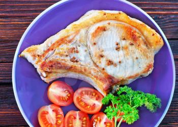 fried steak with tomato on the plate