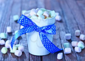 marshmallows in cup and on a table