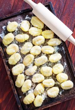 gnocchi from potato on wooden tray and on a table