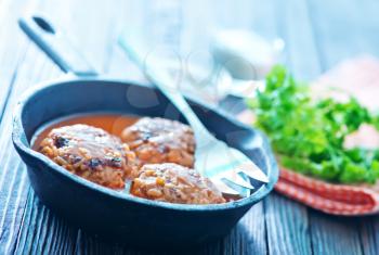 Fried meatballs with tomato sauce and spices in frying pan