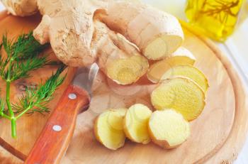 Fresh ginger and knife on the wooden board