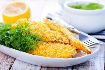 fried fish on plate and on a table