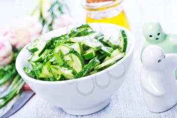 salad with cucumber in the white bowl and on a table