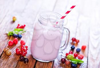 yogurt with berries in glass and on a table