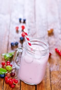 yogurt with berries in glass and on a table