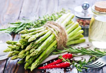 raw asparagus with salt and aroma spice on a table