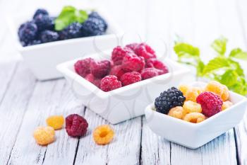 fresh berries in bowl and on a table