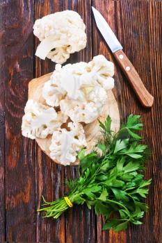 cauliflower and knife on the wooden board