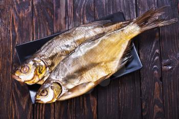 smoked fish on plate and on a table