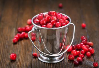 Cranberry in metal bowl and on a table