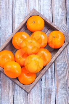 fresh tangerines in wooden box and on a table