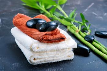 clear towels, black stones and bamboo on a table
