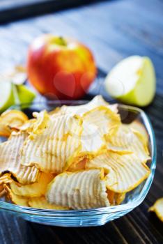 apple chips in bowl and on a table