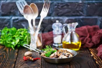 fried mushrooms in pan and on a table