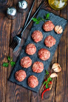 raw meat balls with spice on a table