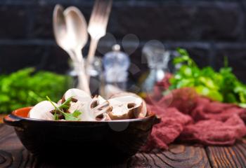 raw mushroom in bowl and on a table