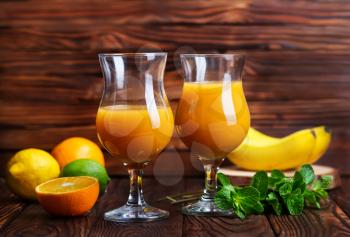 orange juice in glasses and on a table