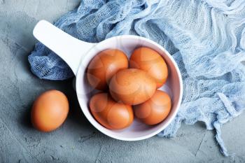 raw eggs in white bowl and on a table