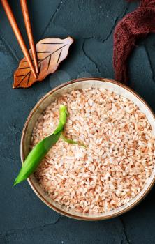raw pink rice in bowl and on a table