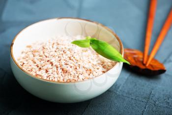raw pink rice in bowl and on a table