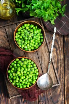 green peas in bowls and on a table