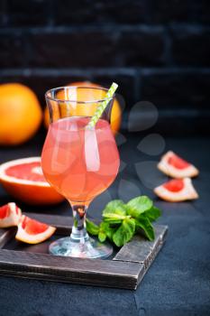 grapefruit juice in glass and on a table