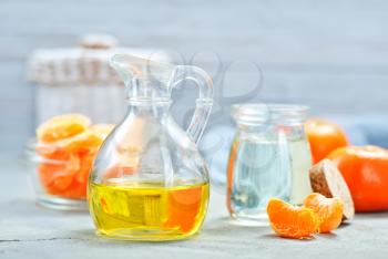 tangerines oil in glass bottle and on a table