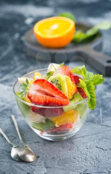 fruit salad in glass bowl and on a table