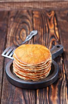 sweet pancakes on plate and on a table