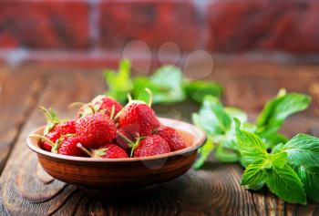 strawberry in bowl and on a table