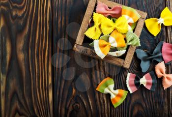 color raw pasta in wooden box and on a table