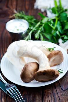 raw mushrooms on plate and on a table