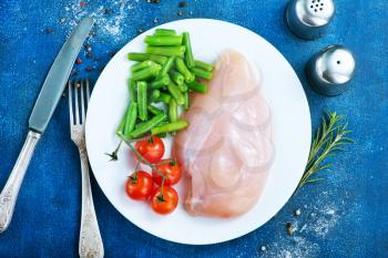 raw chicken fillet and green beans on plate