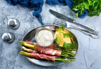 green asparagus with bacon on a table