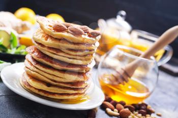pancakes with honey on plate and on a table