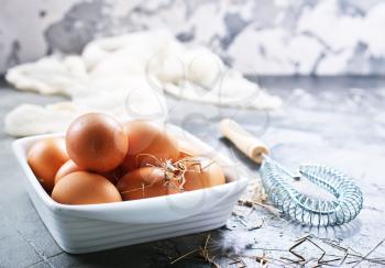 raw eggs in bowl and on a table