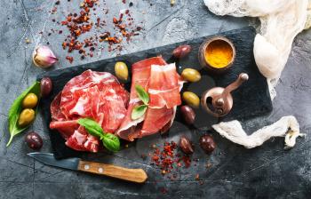 prosciutto with olives and spice on a table